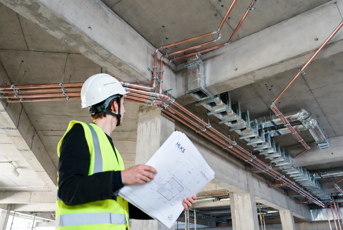 Fachbauleitung HLKS – Bauleiter prüft Installationen auf Baustelle
